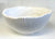 White Ribbed Ceramic Bowl. White ceramic bowl with textured interior on a white background