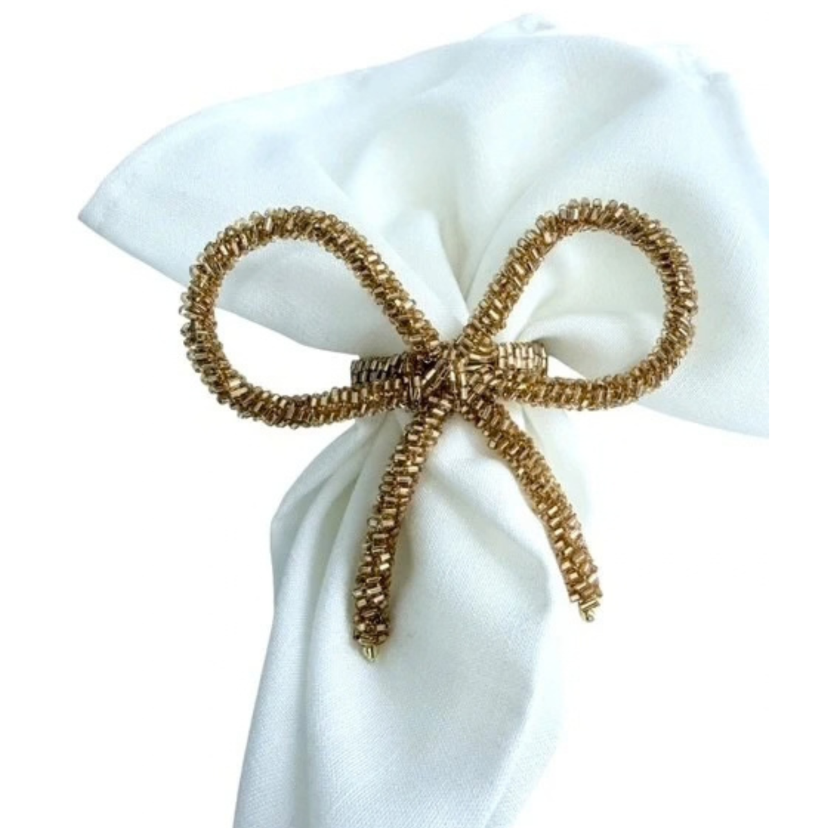 A gold metallic beaded pipe cleaner bow napkin holder tied around a white fabric napkin, shown against a plain white background.