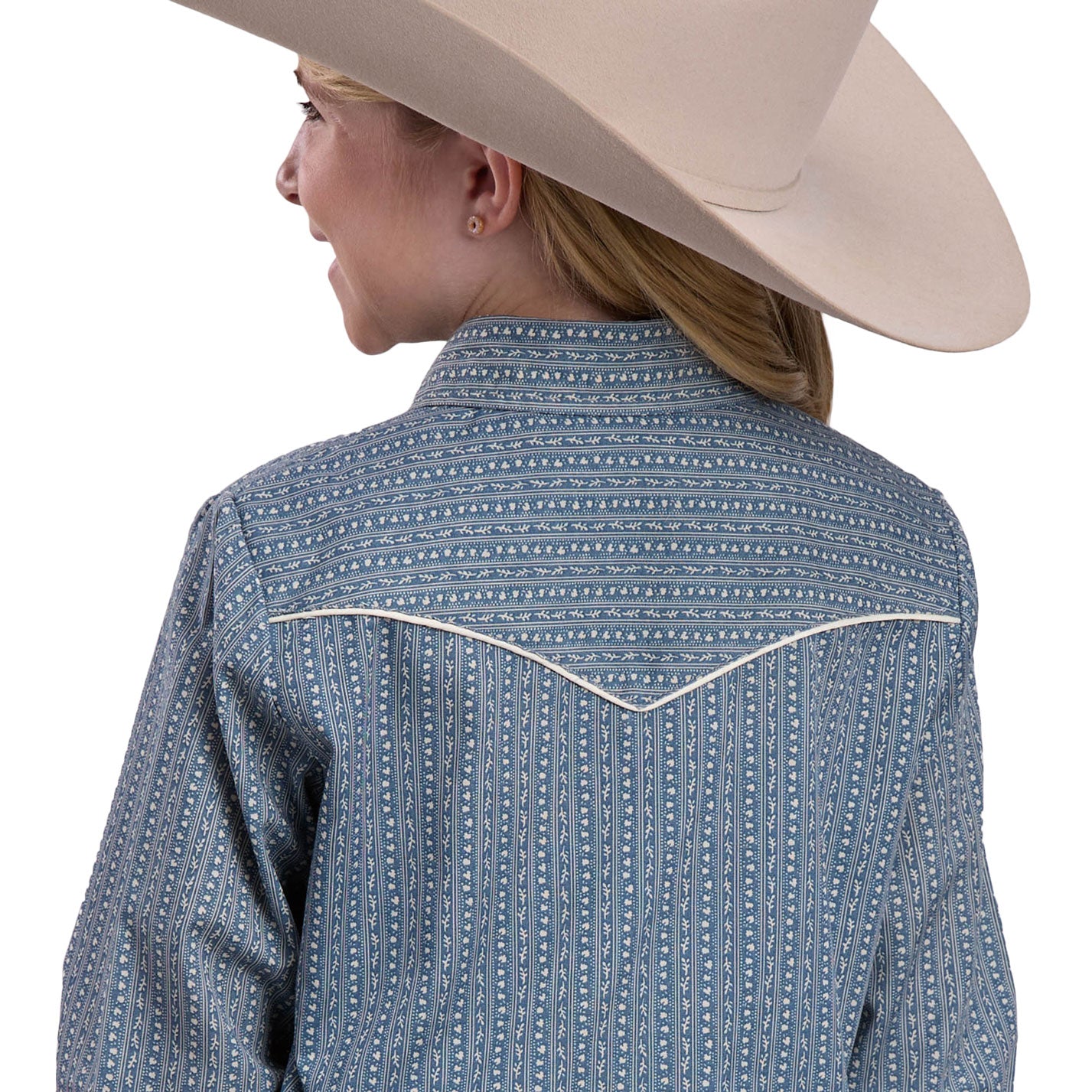 Young girl wearing a blue patterned shirt, jeans, and a beige cowboy hat on a white background
