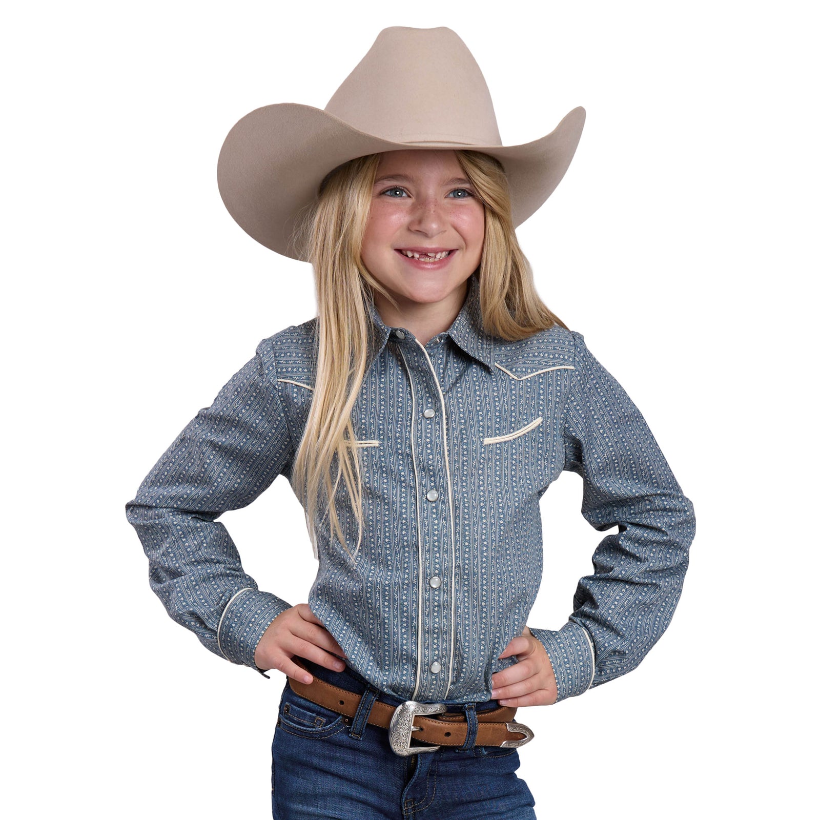Young girl wearing a blue patterned shirt, jeans, and a beige cowboy hat on a white background