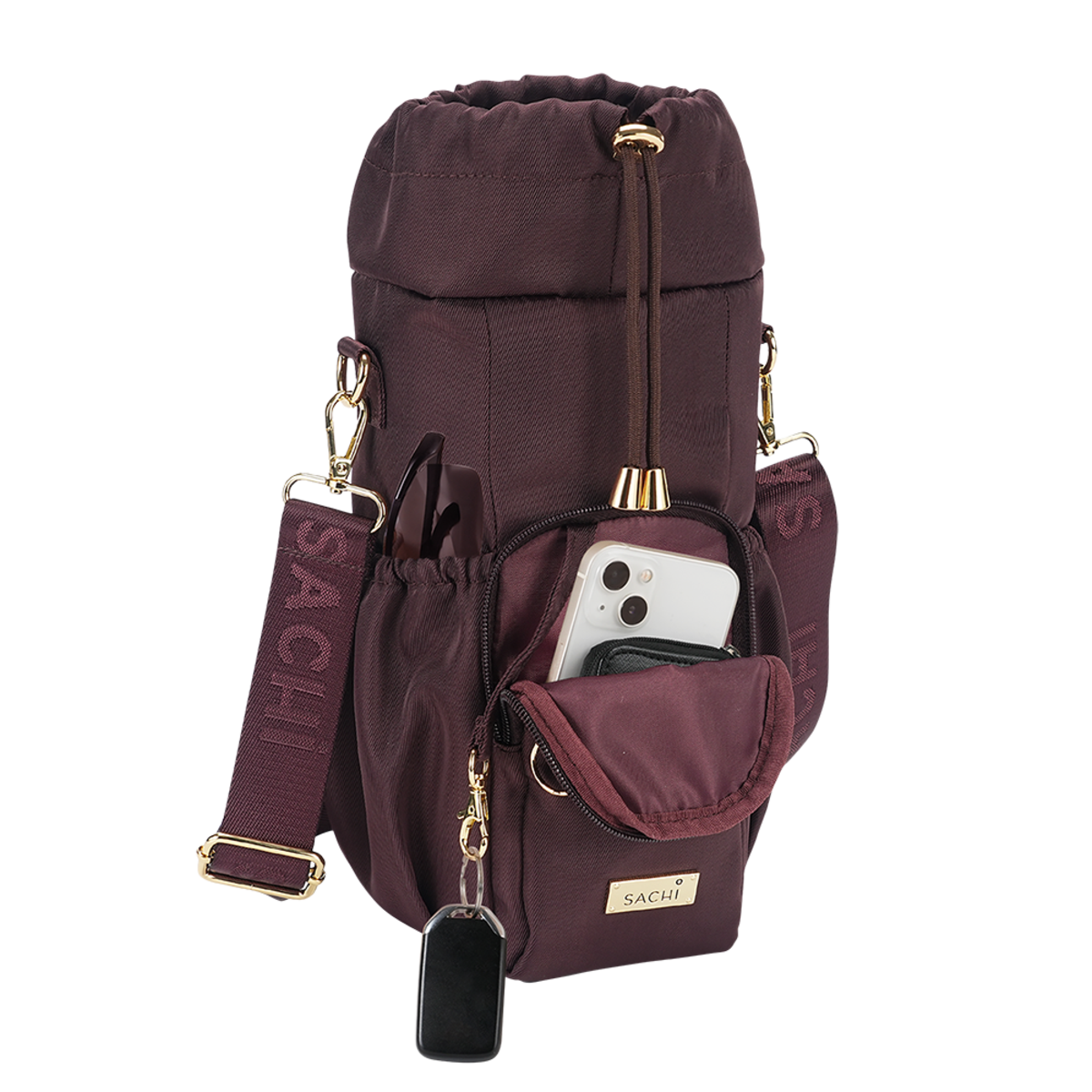 A burgundy drawstring bottle bag with gold-tone hardware, featuring a front zip pocket, side pockets, a detachable shoulder strap, and a small pouch holding a smartphone and wallet. The brand name 'SACHI' is visible on the front patch and embossed on the strap.