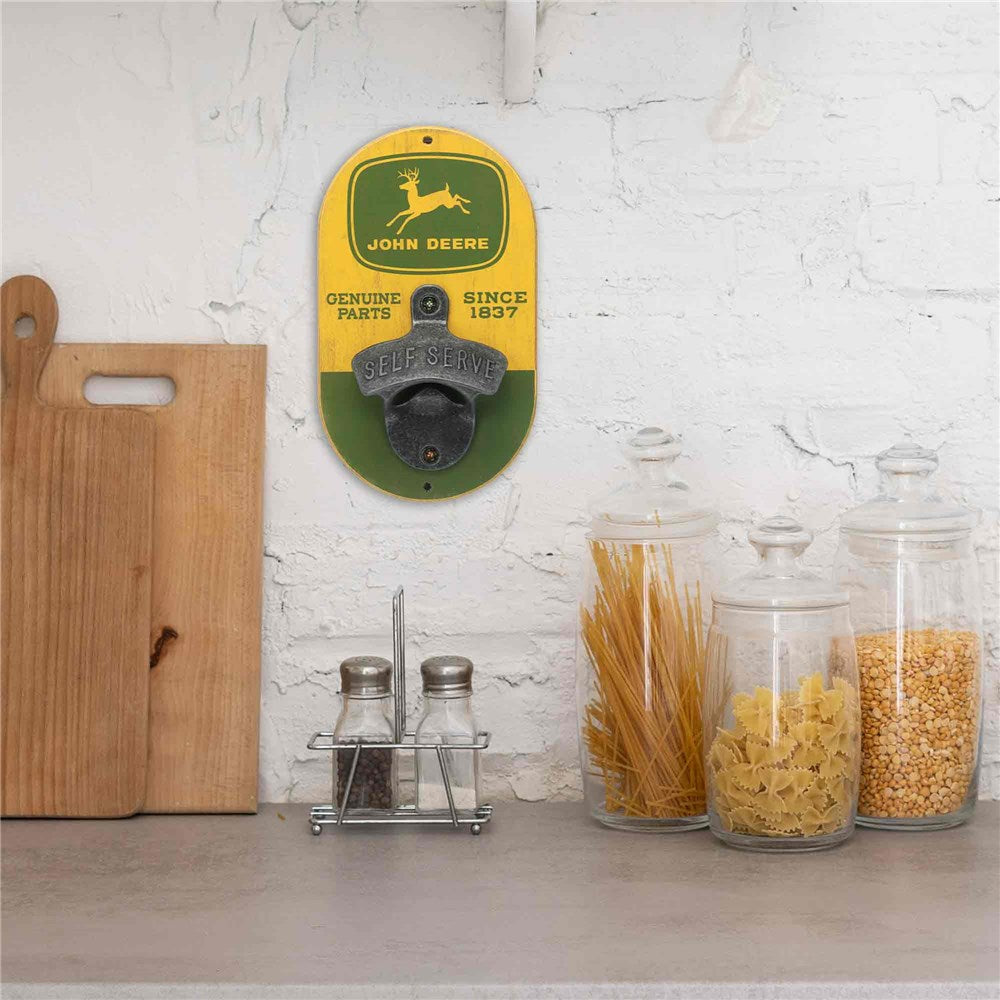John Deere wall-mounted bottle opener on a kitchen counter with jars of pasta and grains.