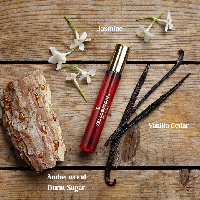 Yellowstone perfume with vanilla, cedar, amberwood, and burnt sugar scents on a wooden surface.