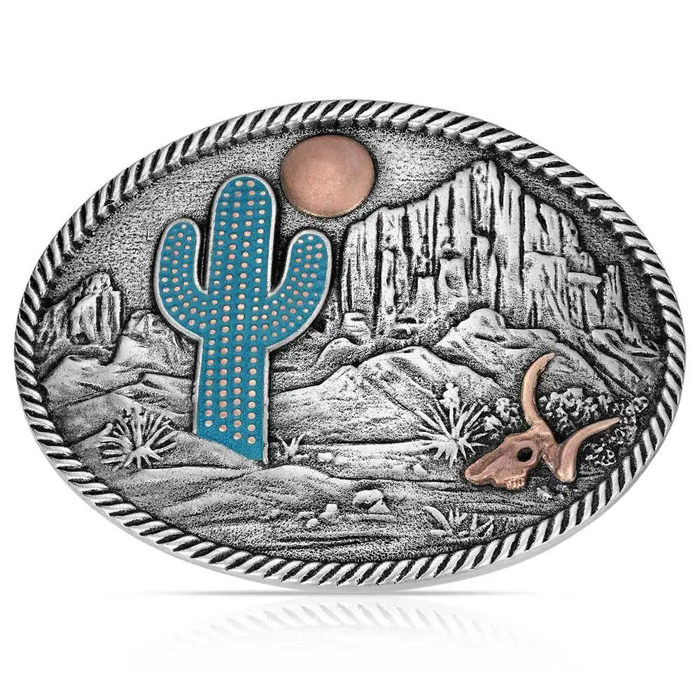 Belt buckle with desert scene featuring a cactus, moon, and longhorn cow on a white background
