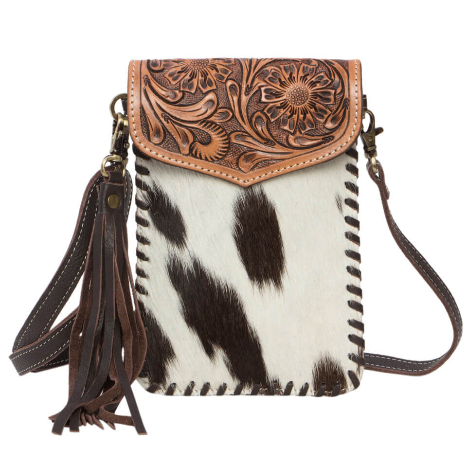 Women's Tooling Cowhide Phone Bag. A brown and white cowhide leather phone bag with tooling details, a magnetic closure, and a detachable leather shoulder strap.