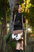 Pasto Tooling Leather Medium Sling Cowhide Bag. Woman holding a brown leather bag with cowhide pattern outdoors