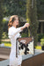 Chillan Tooling Leather Cowhide Sling Bag with Playing Cards Paint Highlight. A woman holding a bag with a cowhide pattern in a sunny outdoor setting.