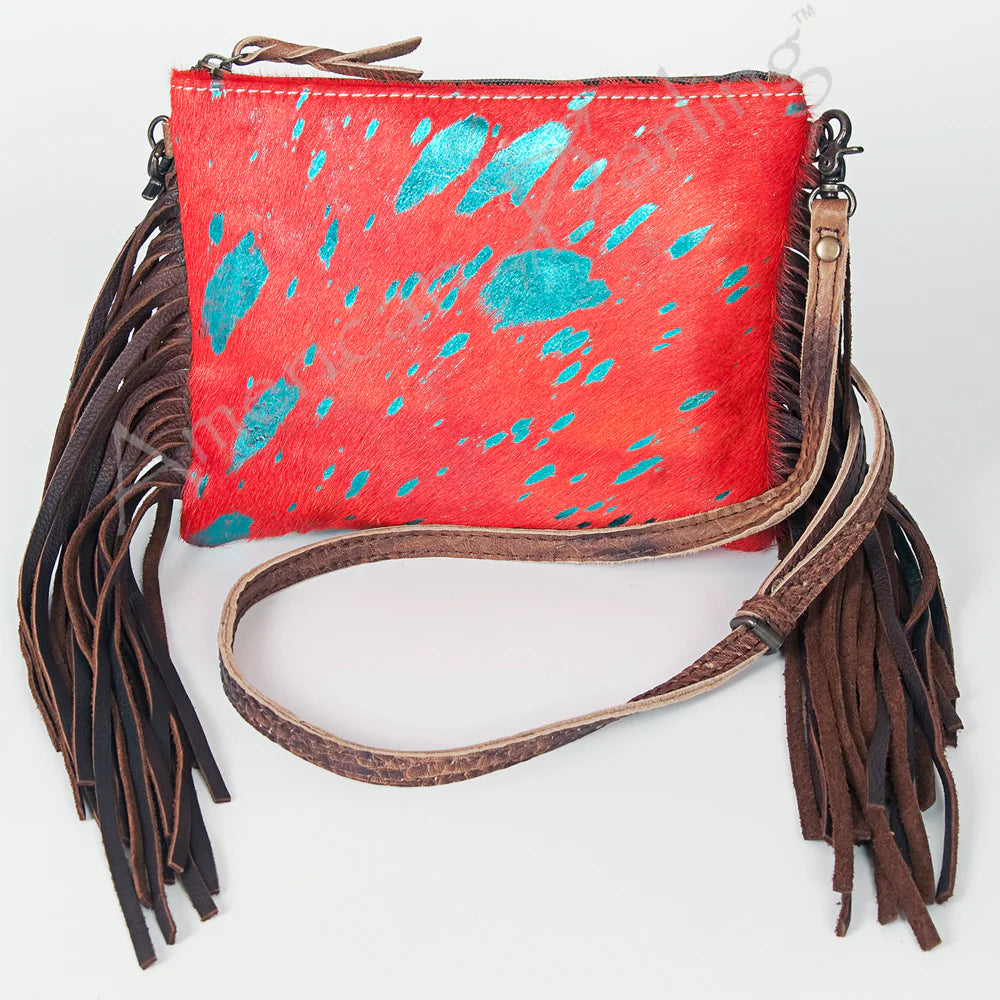 American Darling Western Olivia Hide Crossbody Bag. Red handbag with blue speckles and brown fringes on a white background