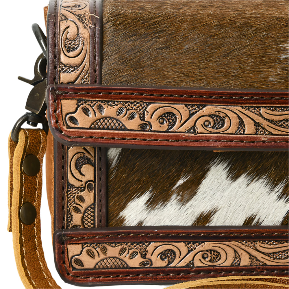 American Darling Close-up of a leather western bag with cowhide and intricate patterns