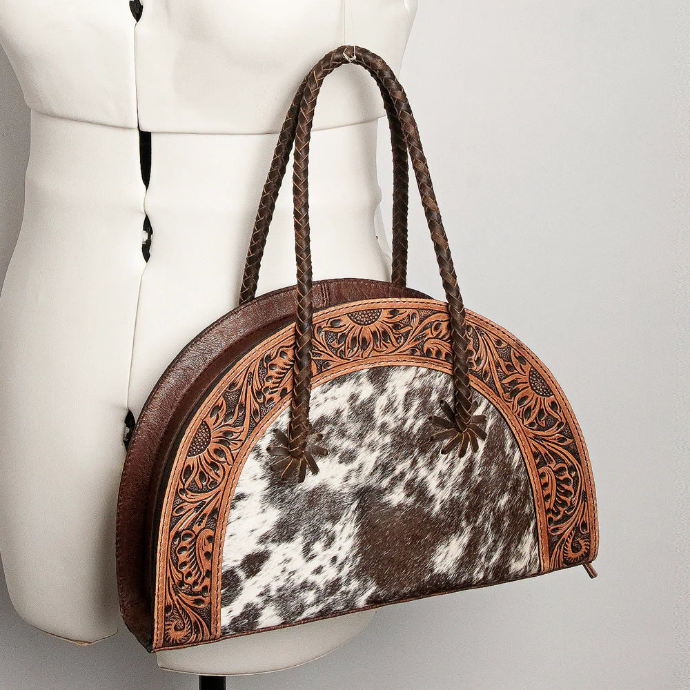 American Darling Tooled & Hide Western Tote. Handbag with cowhide leather and intricate brown leather trim on a mannequin.