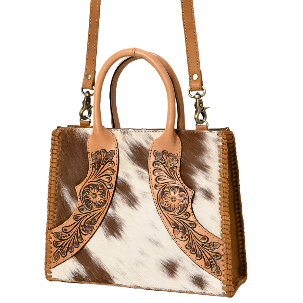 American Darling women's western tote handbag with tooled leather detailing and a cowhide pattern, in brown and white colors, with shoulder straps.