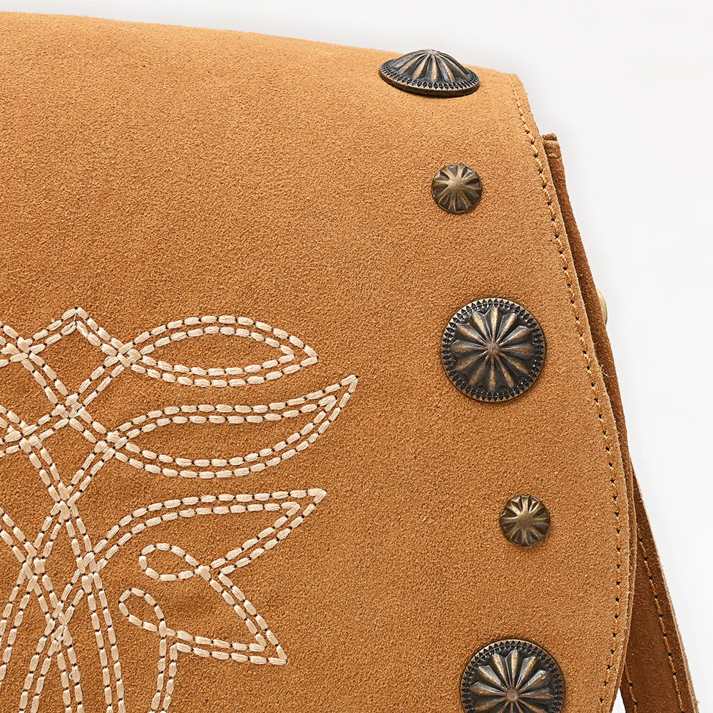 American Darling Suede Boot Stitch Western Handbag. Close-up of a brown leather bag with decorative stitching and metal studs.