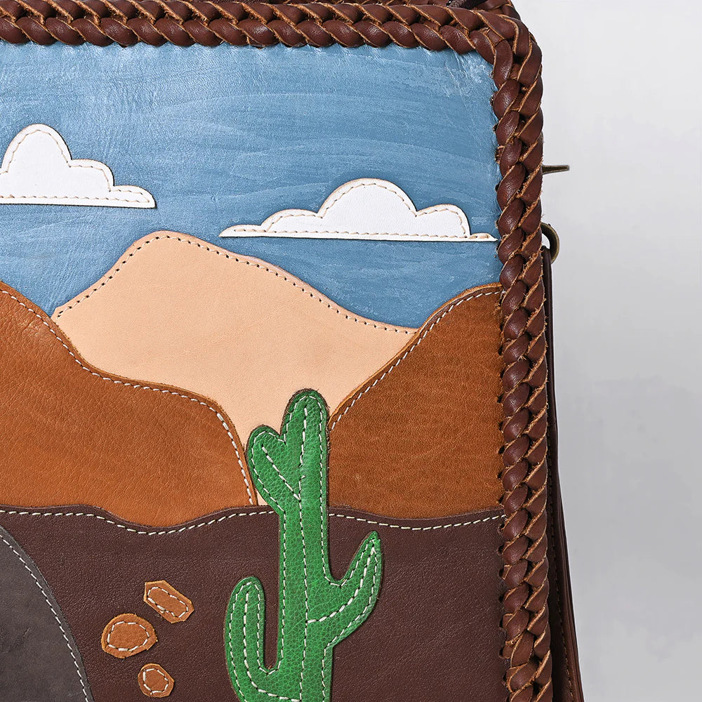 American Darling Desert Road Applique Western Tote. Handbag with desert landscape design featuring mountains, sky, clouds, cactus, and rocks.