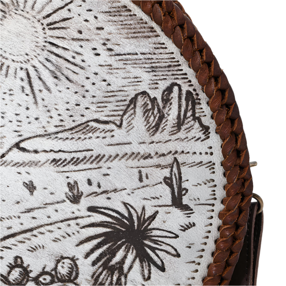 Close-up of American darling round western scene handbag with desert landscape design and brown leather strap.