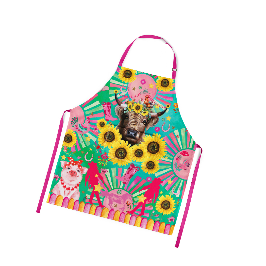 Lisa Pollock Carnival Cow Apron. Colorful apron with a cow and sunflower design on a white background