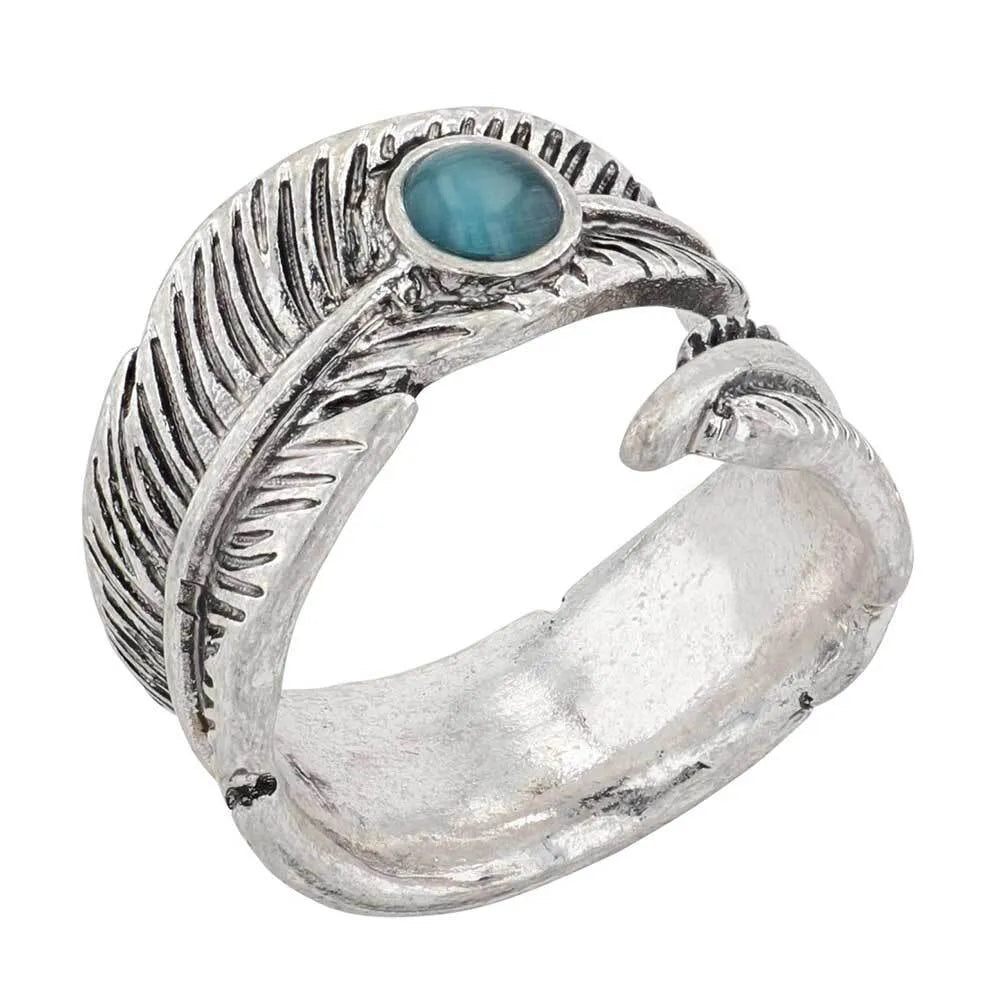 Montana Silversmiths Feather Touch Attitude Wrap Ring. A silver-colored metal ring with a feather design and a turquoise stone at the top, against a white background.
