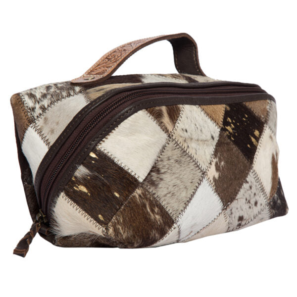 Women&#39;s Cowhide Patchwork Cosmetic Bag. A brown and beige cowhide patchwork cosmetic bag with a top zipper closure and a hand carved leather strap.