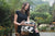 Women's Patchwork Cowhide and Tooling Leather Makeup Bag. Woman holding a checkered handbag in a garden setting
