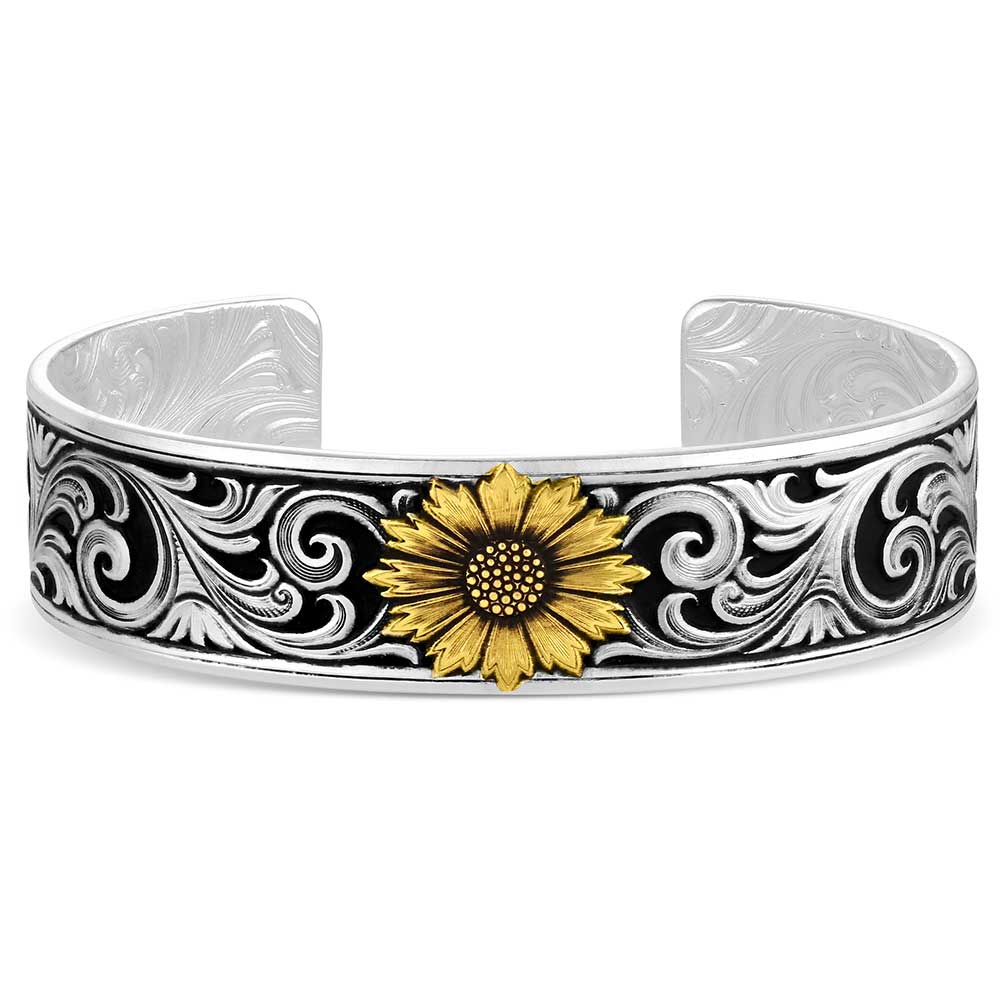 A silver cuff bracelet featuring an engraved black and silver scroll pattern with a central gold sunflower accent, shown on a plain white background.