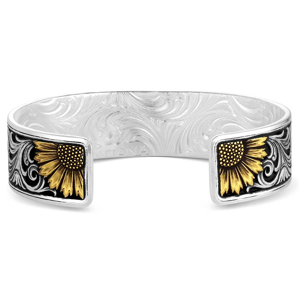 A silver cuff bracelet featuring two rectangular floral inlays on the front. The inlays depict yellow sunflower-like petals with dark centers and black scrollwork details on a white background.