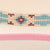 Charlie 1 Horse Gracie JR Straw Cowboy Hat. Close-up of a beaded ribbon with pink ribbon underneath on a beige background
