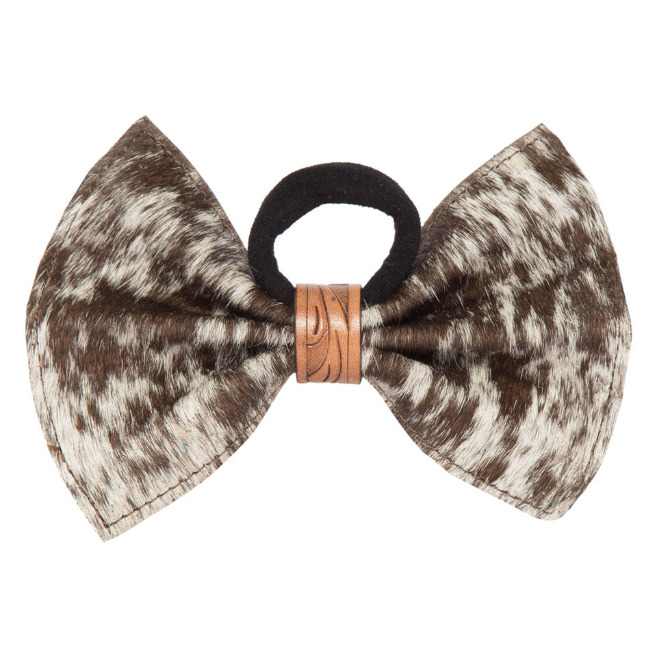 Women's Cowhide Leather Bow Hair Tie. A brown cowhide leather hair tie with a bow shape and a branded ring in the center.