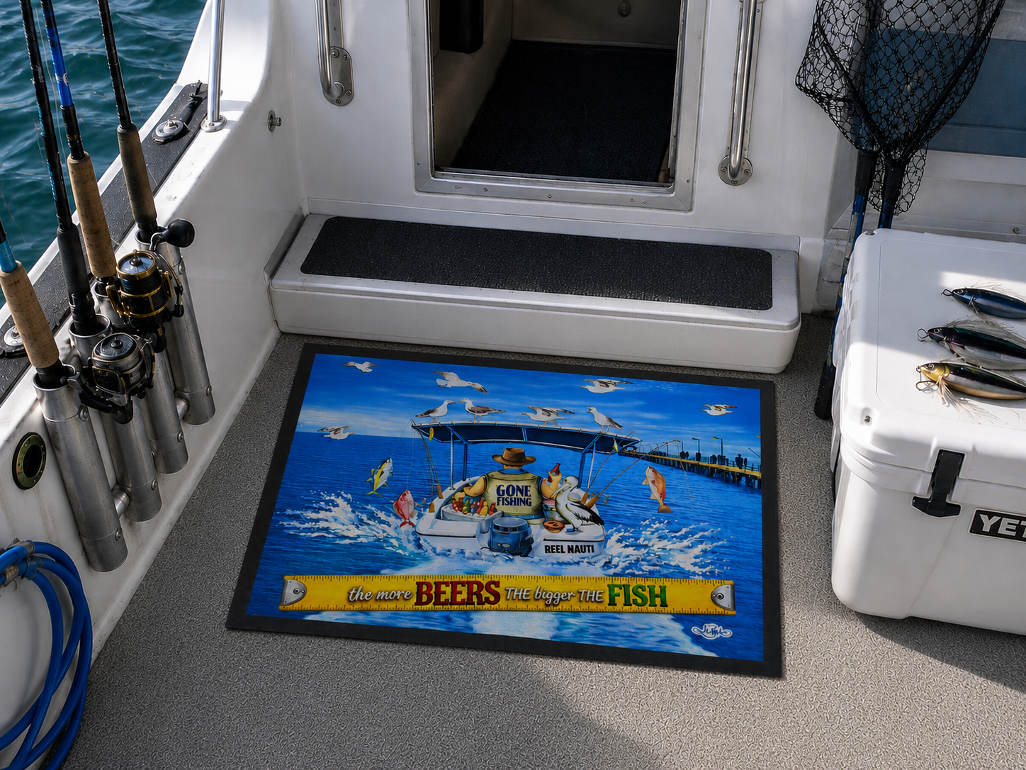 A rectangular printed mat on the deck of a boat, featuring a colorful illustration of a fishing boat with the text 'We Love BEERS & Walleypolis FISH'. The mat is shown in a real-world boating environment alongside fishing rods, a cooler, and water.