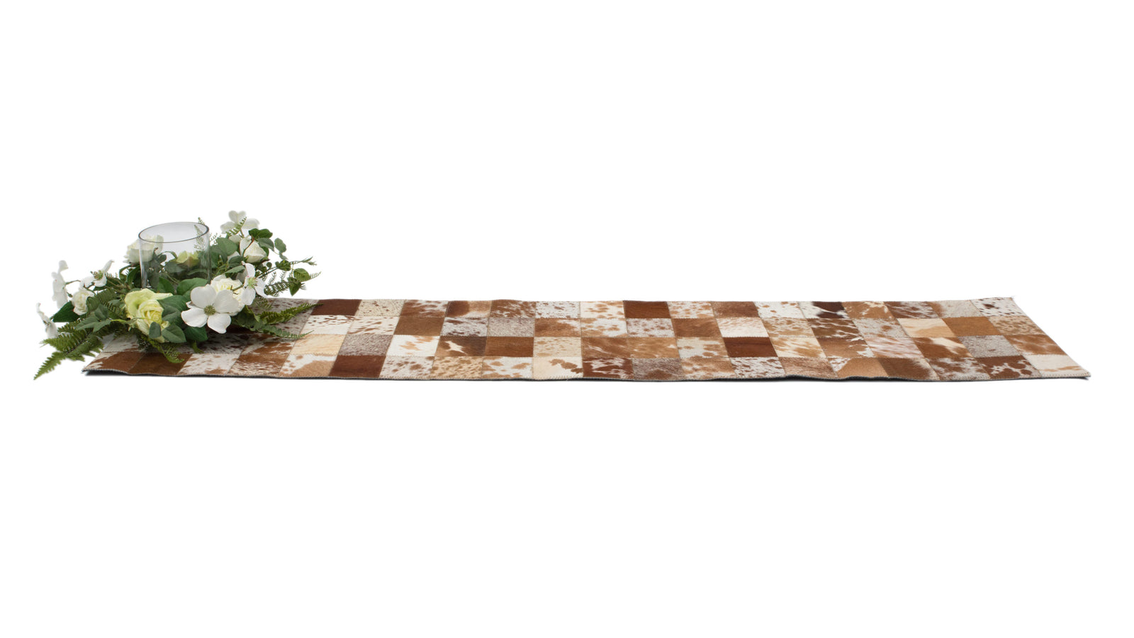 Cowhide Table Runner. Checkered cowhide table runner with floral arrangement on a white background