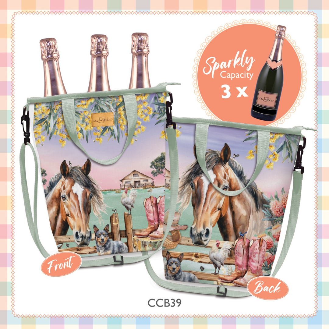 A reusable tote bag shown from front and back, printed with a whimsical farm scene featuring brown horses, pink sheep, a small house, and yellow flowers. The bag has pale green handles and straps, black plastic hardware, and is displayed with three champagne bottles inserted to demonstrate its 'Sparkly Capacity 3 x' use.