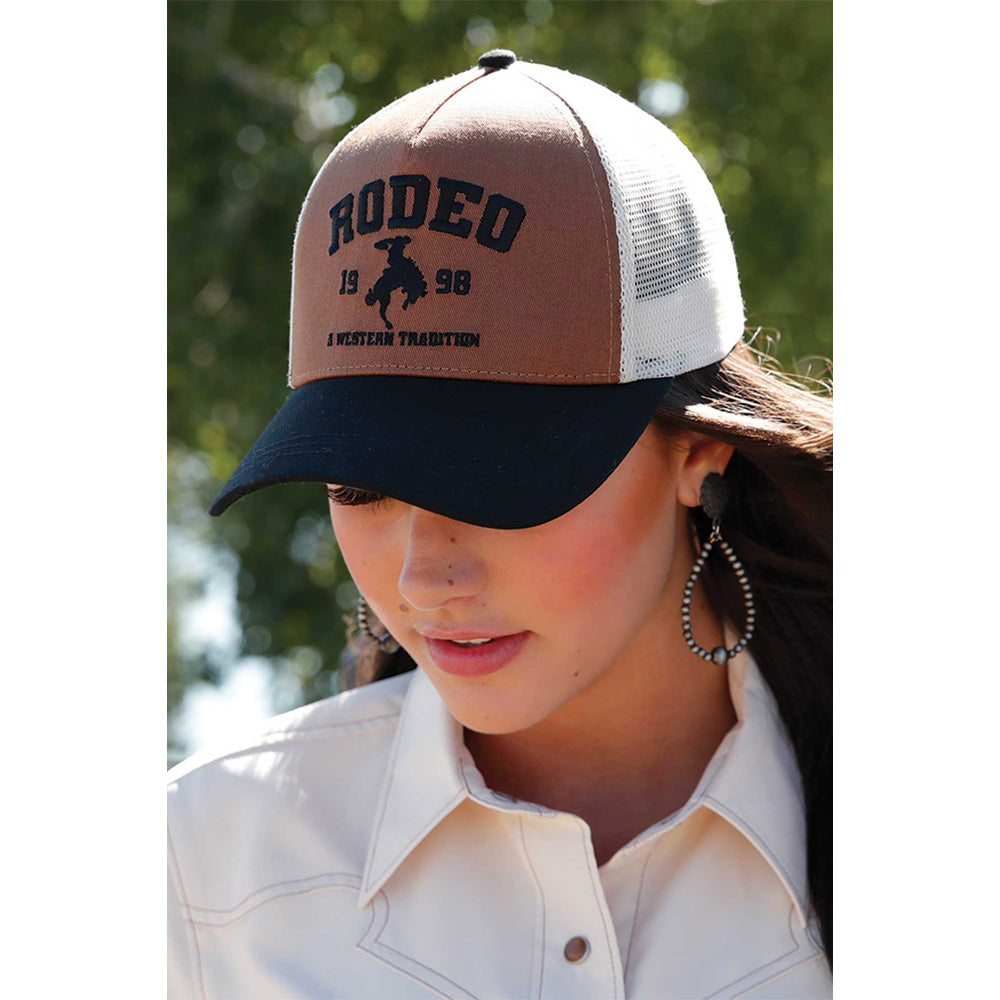 Cruel Denim Women's Trucker Cap. Person wearing a cap with 'Rodeo' text and logo outdoors