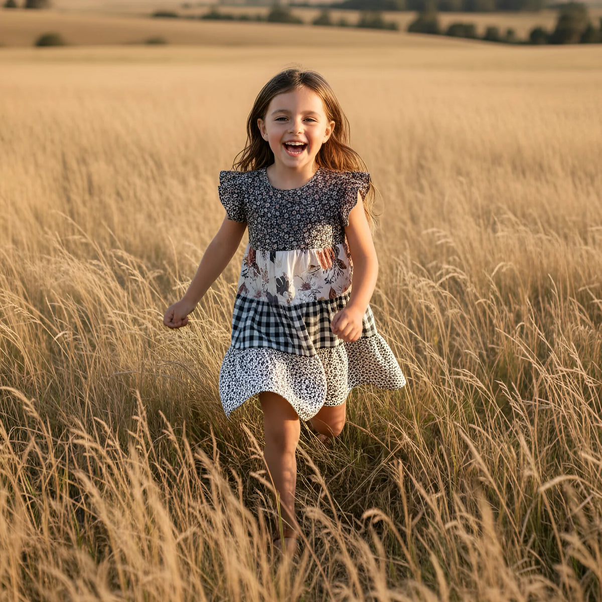 Young girl running through a field of tall grass with a scenic background
