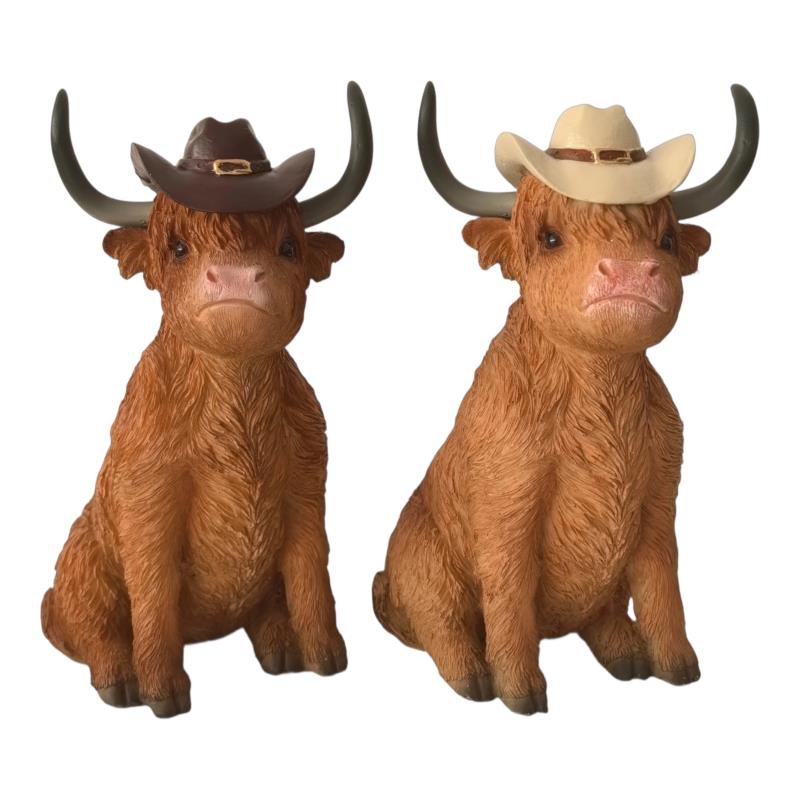 Two cow statues, one wearing a brown cowboy hat and the other a beige cowboy hat, on a white background.