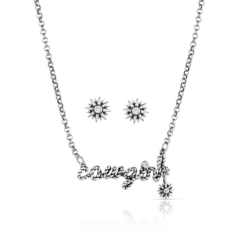 Montana Silversmiths For The Cowgirls Jewellery Set. A silver jewelry set featuring a necklace with the word 'Cowgirl' written in cursive and a pair of earrings with clear cubic zirconia crystals and silver spikes.