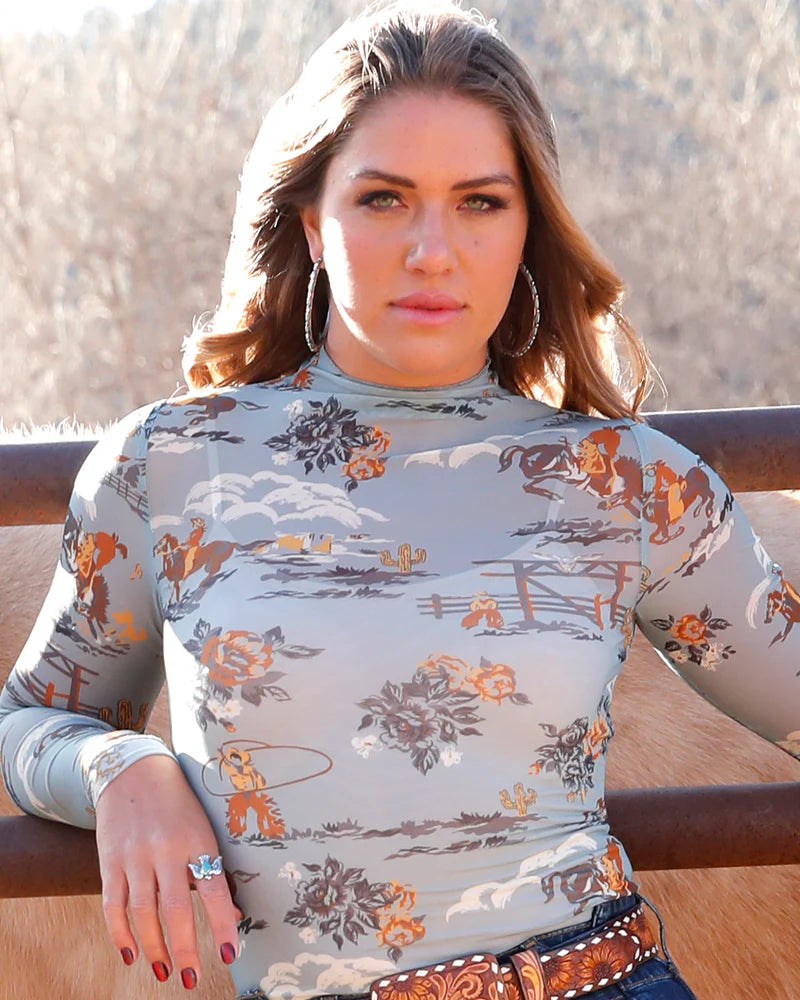 Woman wearing a patterned long-sleeve shirt with a scenic background