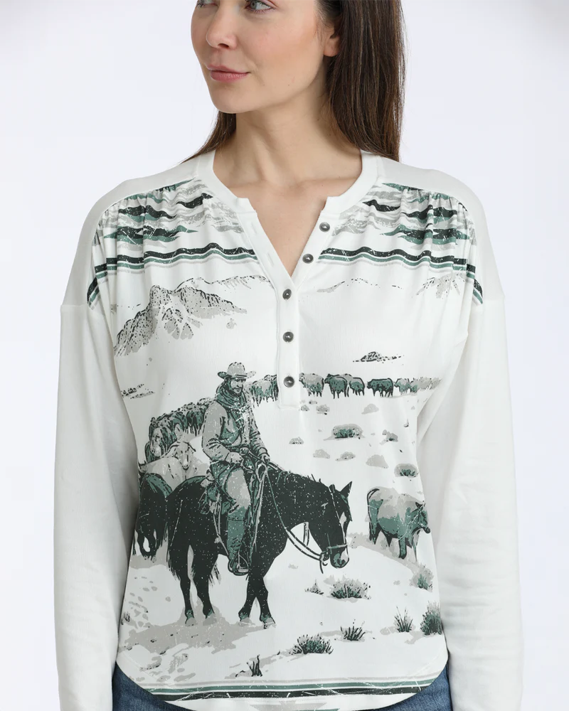 Woman wearing a white long-sleeve shirt with a cowboy and horse print on a white background