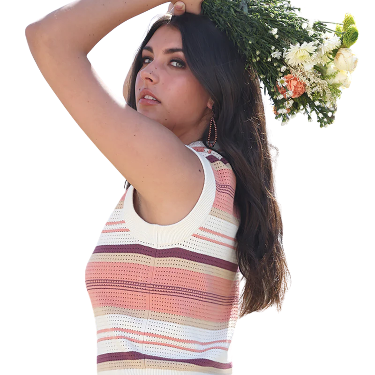 Woman wearing a colorful striped sleeveless top holding flowers against a white background
