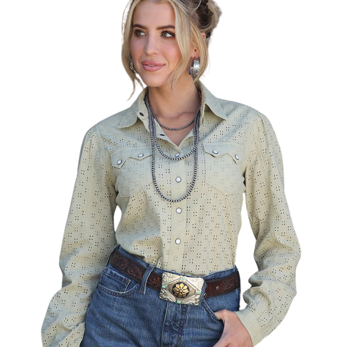 Woman wearing a light-colored long-sleeve shirt with decorative buttons and blue jeans on a white background