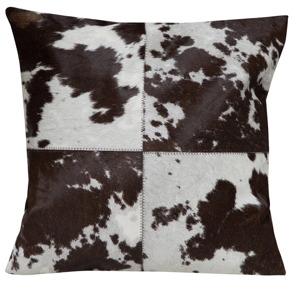 4 Panel Cowhide Cushion. Decorative pillow with black and white patchwork pattern on a plain background
