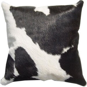 Single Panel Cowhide Cushion. Cow print pillow with black and white pattern on a plain background