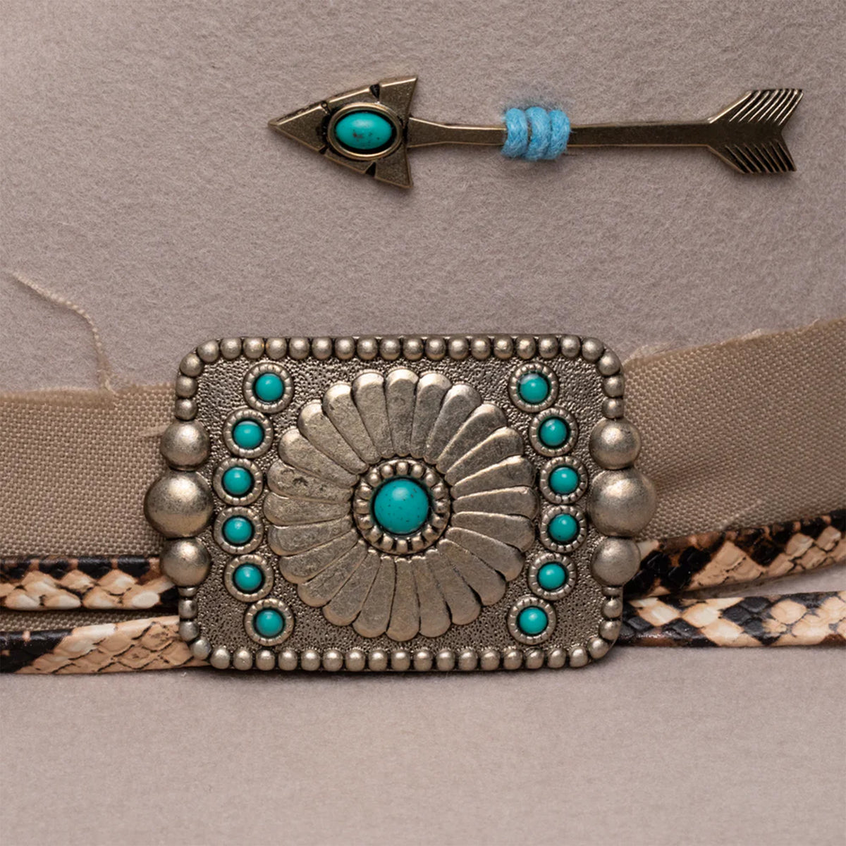 Charlie One Horse Spear Point Felt Cowboy Hat. Belt with decorative buckle and arrow hair accessory on a neutral background