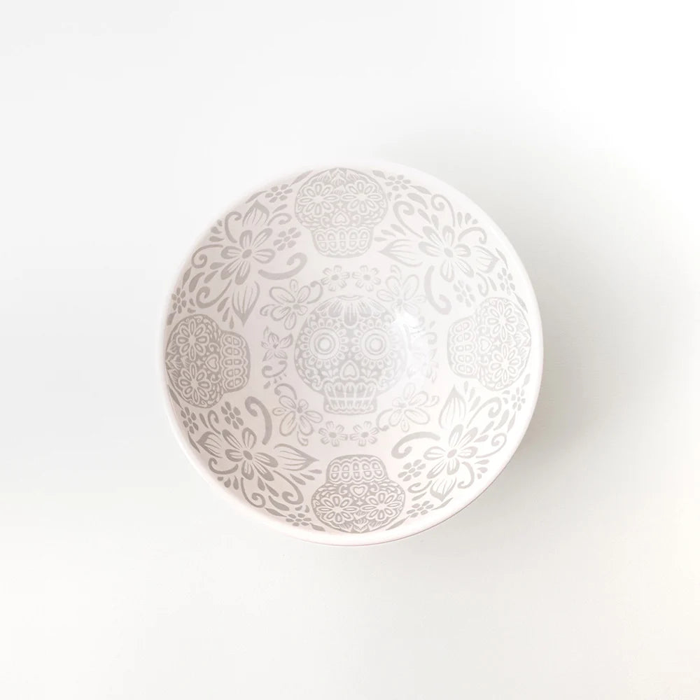 A small white ceramic bowl with a delicate gray floral pattern inside, standing on three short feet against a clean white background.