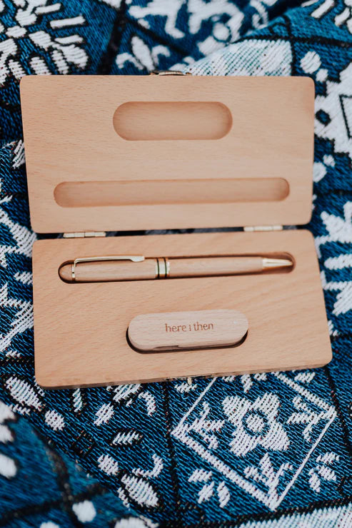 Here And Then Box - Natural. Wooden pen set with 'here i then' engraving on a patterned fabric background