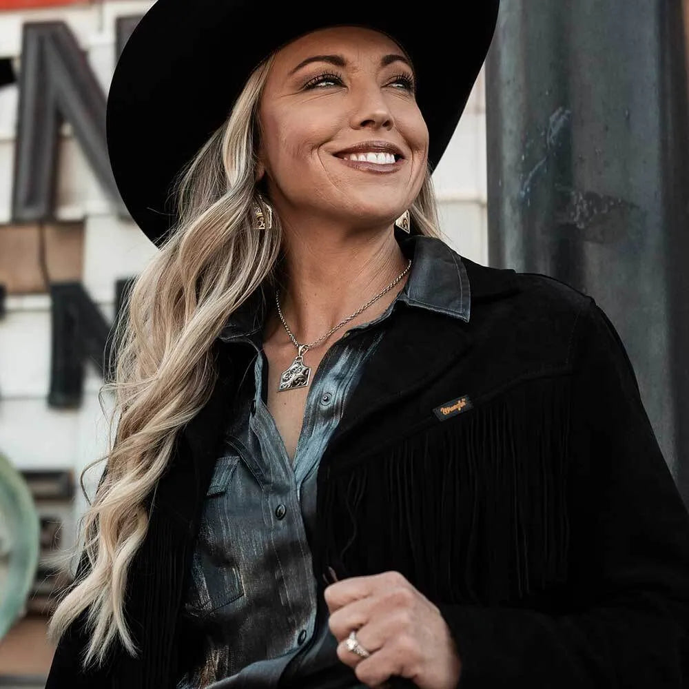 Woman wearing a black hat and coat with a blurred background