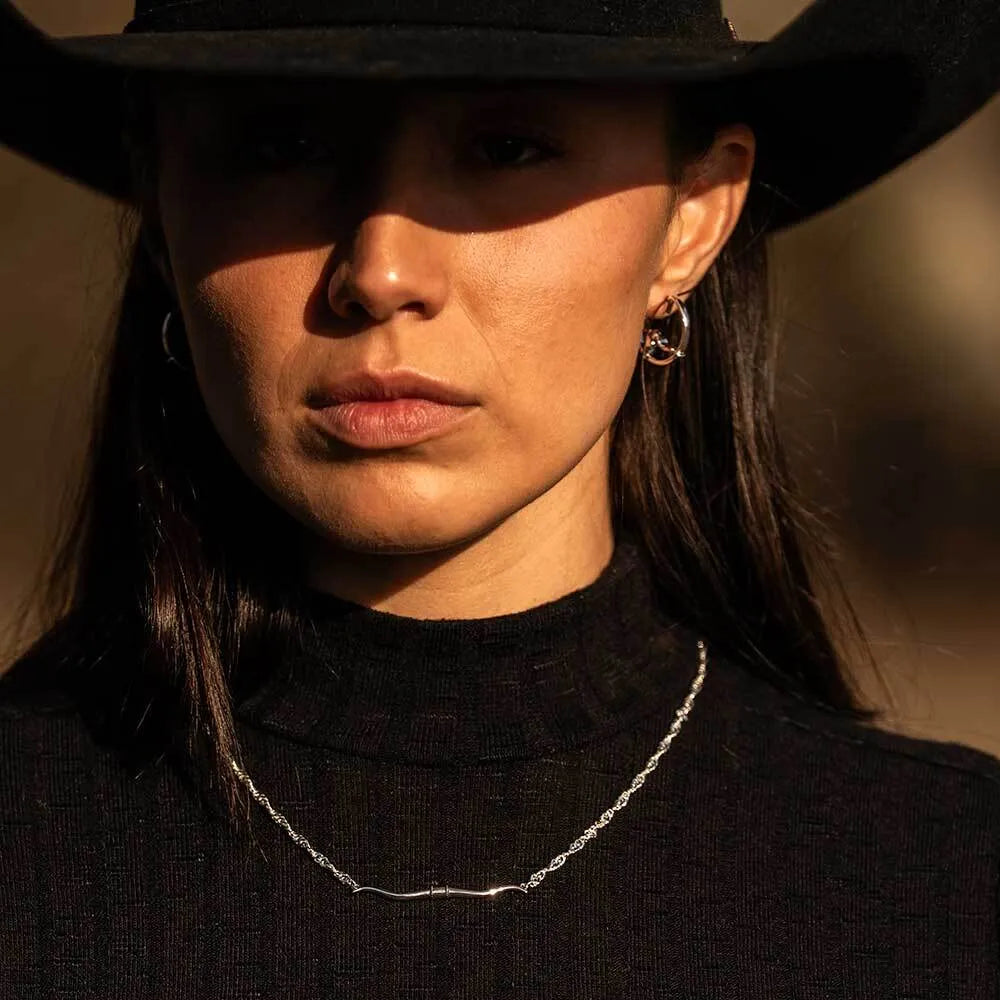 Woman wearing a black hat and black turtleneck with a blurred background