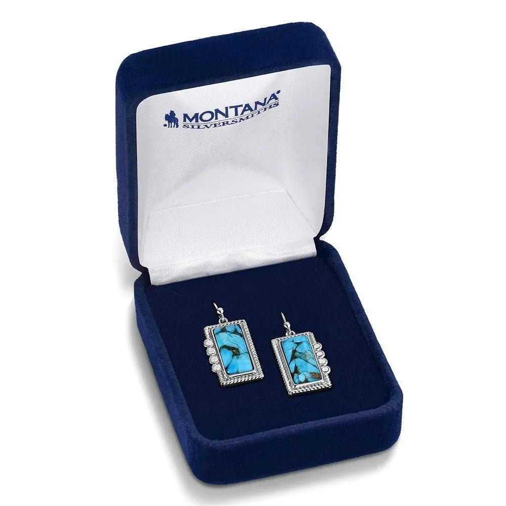 Turquoise earrings in a blue jewelry box with 'Montana Silversmiths' branding.