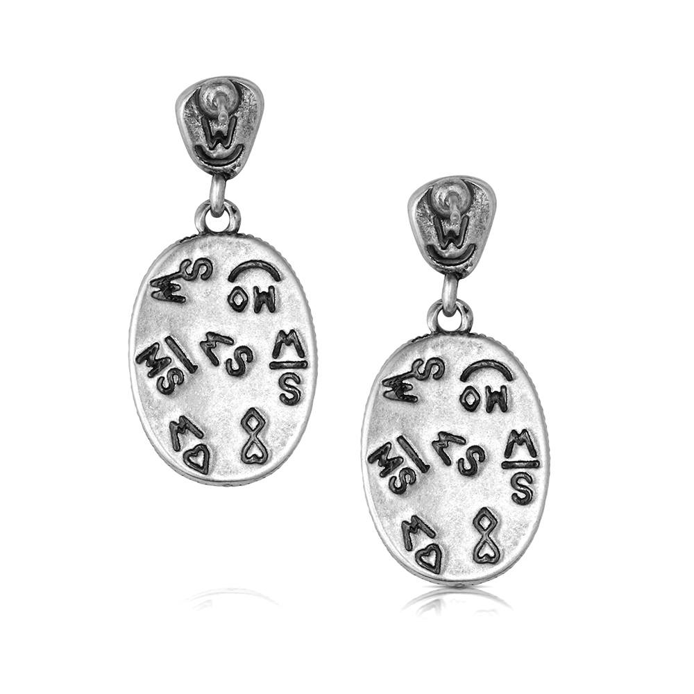 A pair of silver-toned oval drop earrings with engraved symbols and lettering, shown on a clean white background.