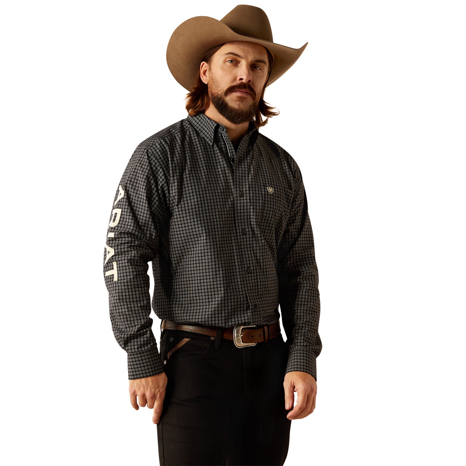 Ariat Men's Pro Series Team Otto L/S Western. A man wearing a long-sleeved checkered Western shirt in black and white, with the brand name 'Ariat' visible on the sleeve, paired with black pants and a cowboy hat.