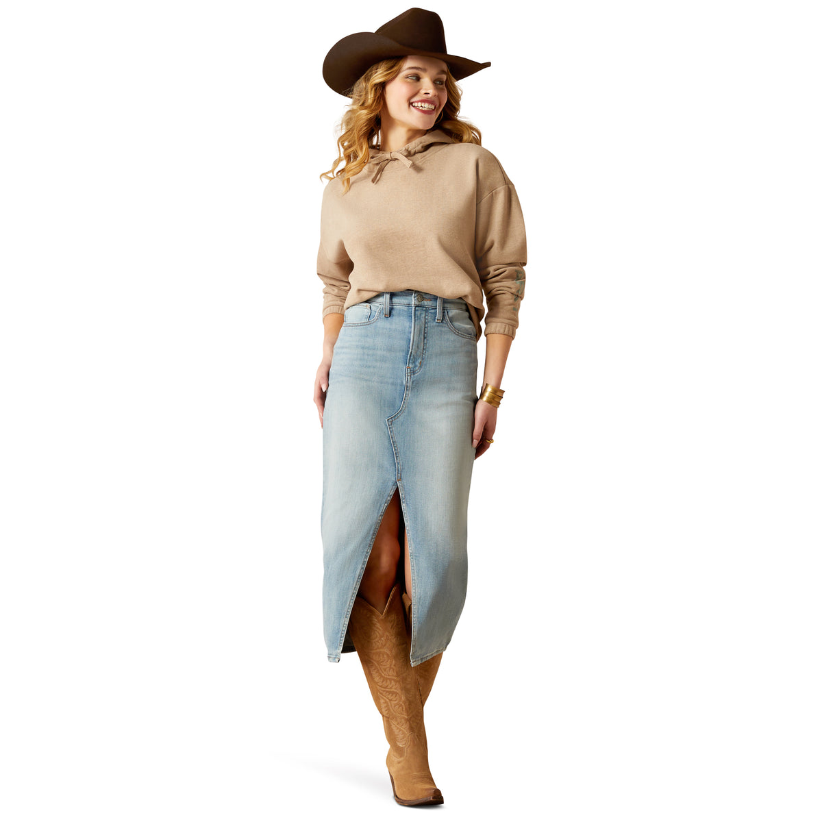 Ariat Women's Essential Logo Hoodie. Woman in beige sweater and denim skirt with cowboy hat on white background