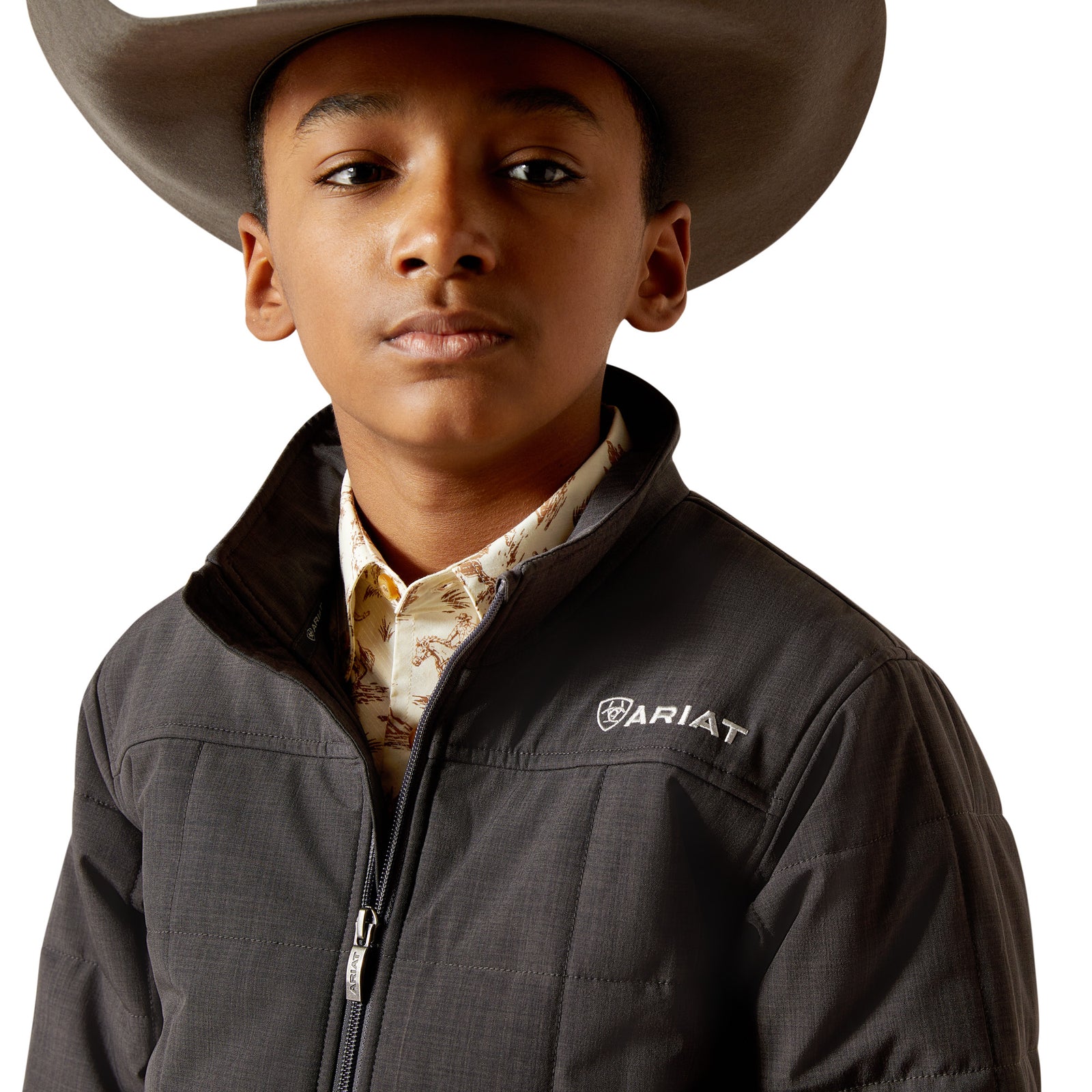 Child wearing a dark gray jacket and cowboy hat on a white background