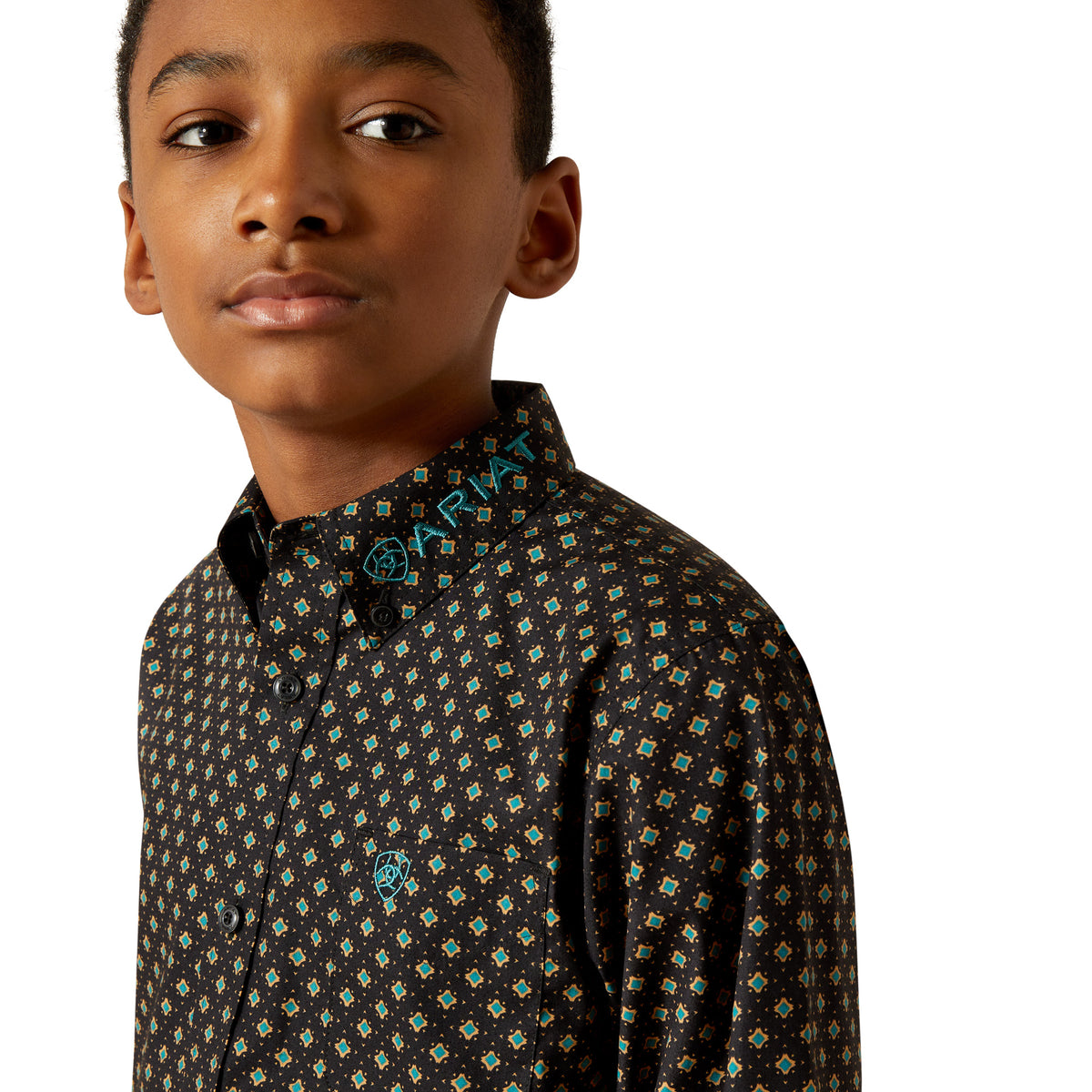Young boy wearing a patterned shirt with a brand logo on a white background